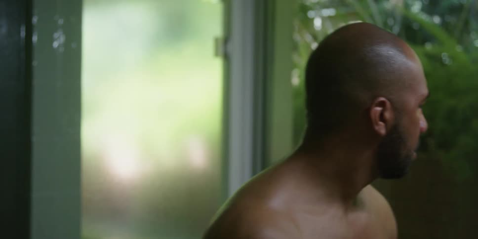 Bald man with beard washes and dries his face with a blue towel in the bathroom