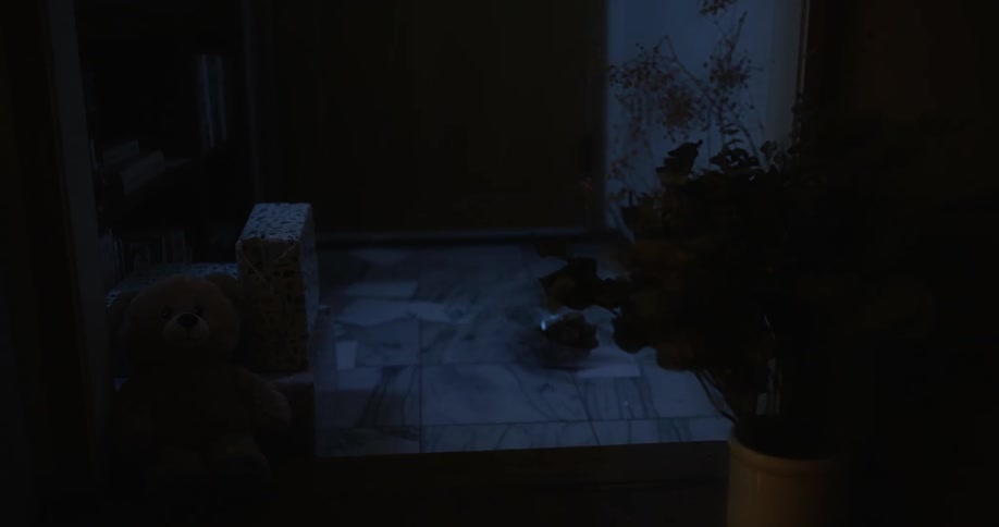 Teddy bear resting on the floor of a dimly lit room at night