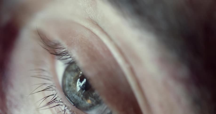 Close up of a person reflecting on an eye under a bright light