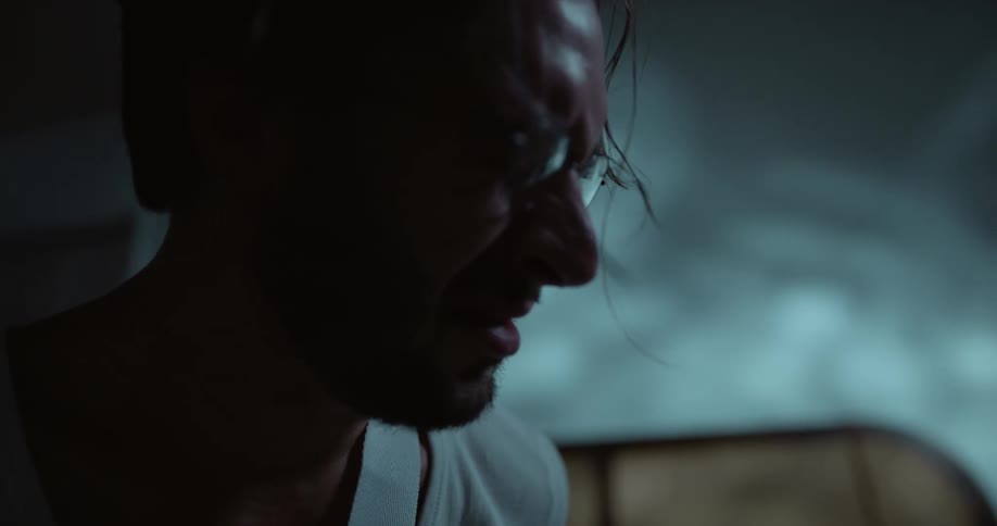A man removing his glasses to rub his face and head
