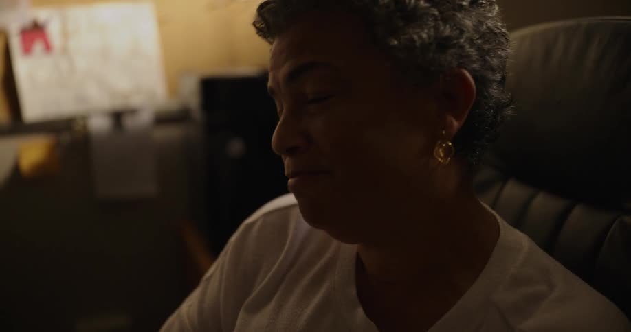 A woman is sitting in an office nodding her head and smiling as she speaks