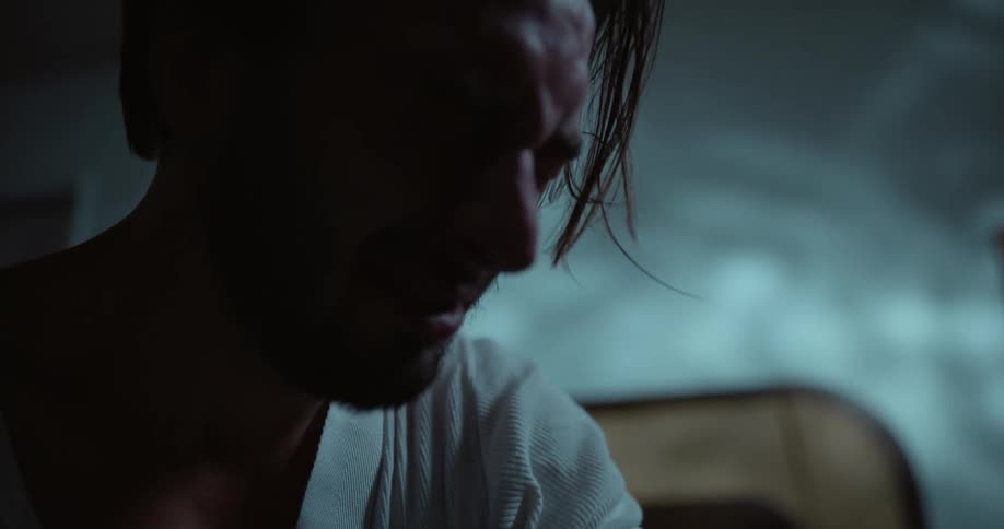 A man is crying while sitting in bed