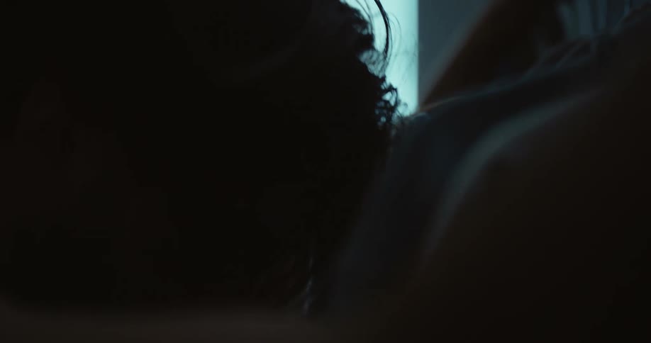 Shirtless man with glasses and beard cries and holding pipe clothing rack in room