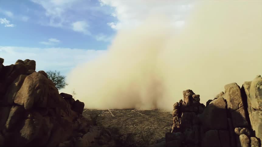 Intense Haboob carries giant wall of dust over a town toward mountain ridges