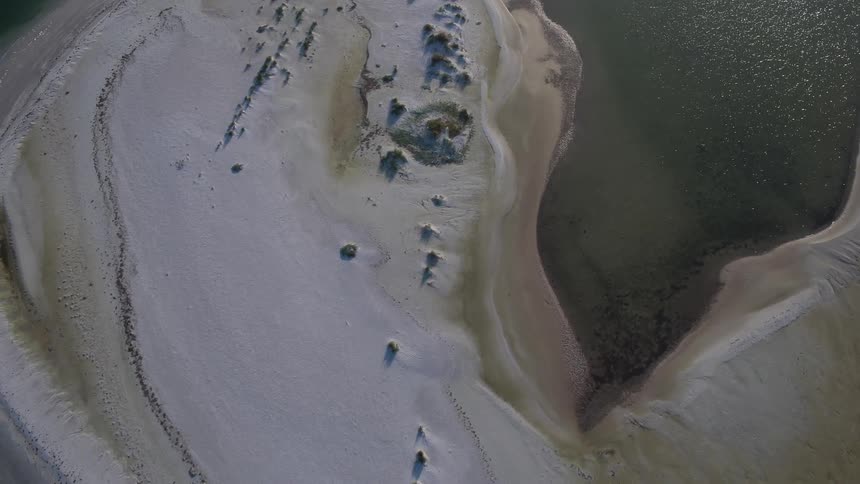 A small island is surrounded by water below