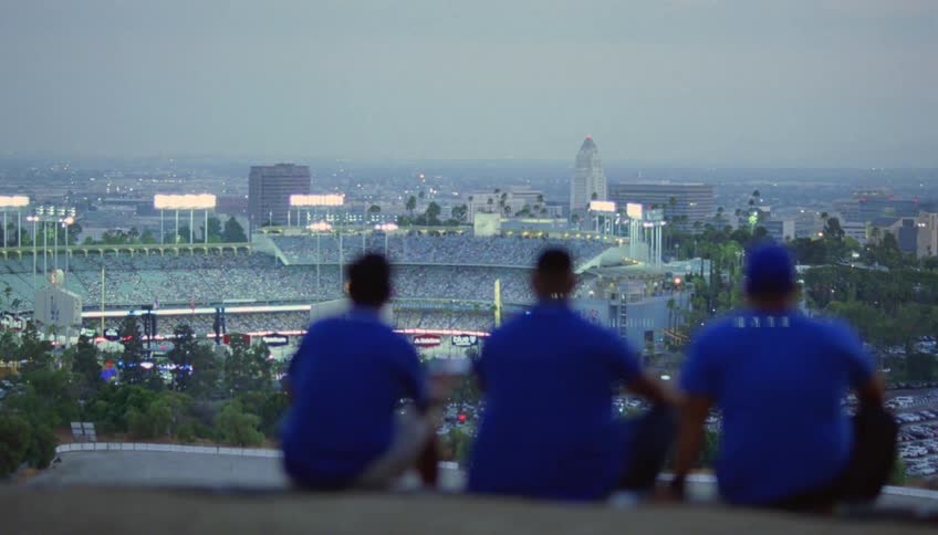 Three friends sitting overlooking dodger stadium watching a game