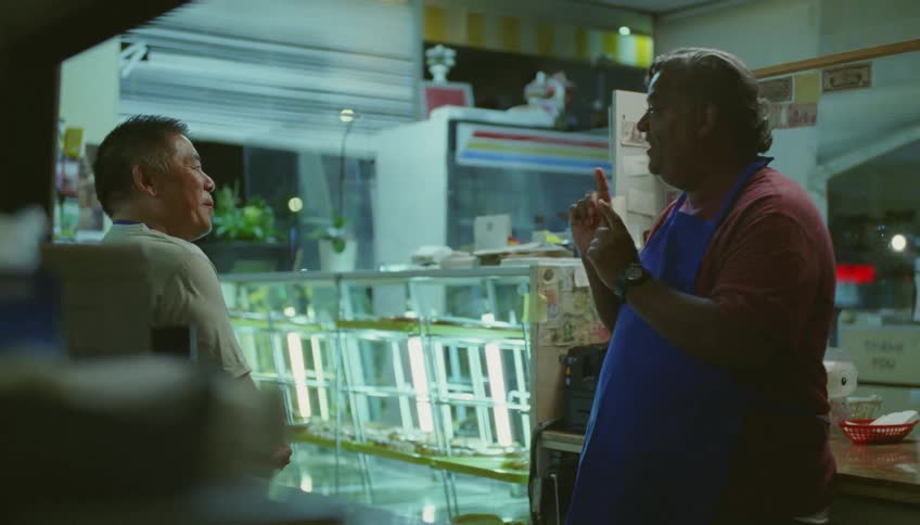 Restaurant workers laugh and talk in restaurant at night