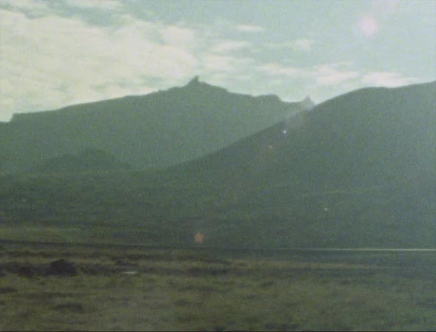 An empty highway runs next to a lot of mountains