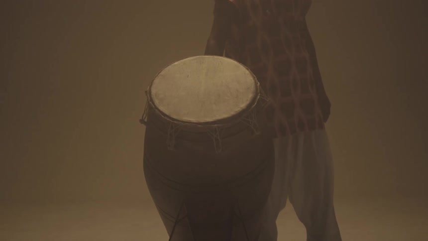 A man is holding a large drum next to him