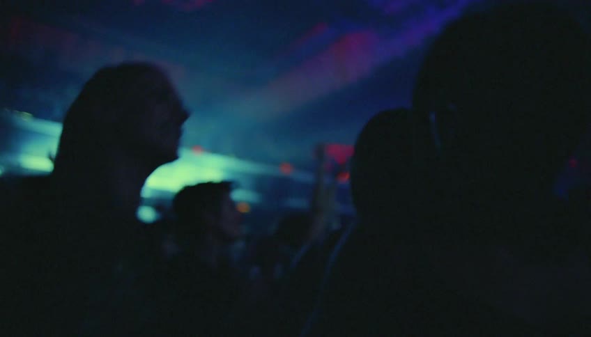 Friends smile at each other while dancing at night club