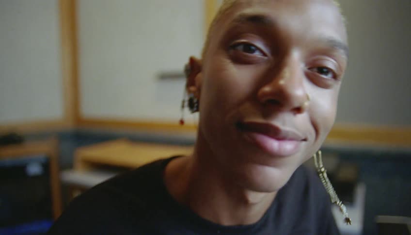 Young person wearing various types of earrings dancing to the music