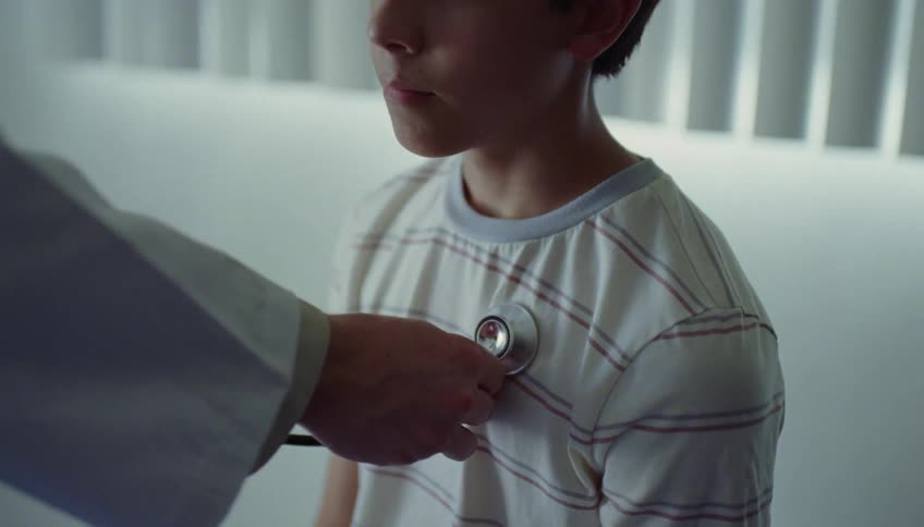 Pediatrician treats boy using stethoscope in the clinic