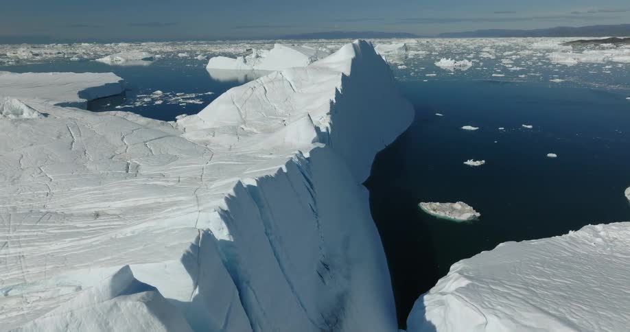 Broken sections of an iceberg float in the sea