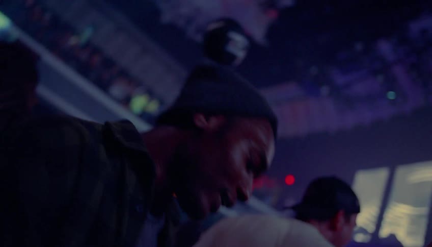 People dance at night club while laser lights move overhead