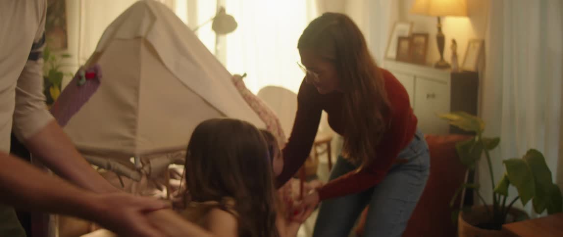 Mom and dad are dancing with their little girls and holding their hands