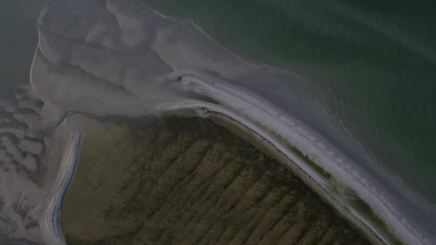 Waves crash against the shore below