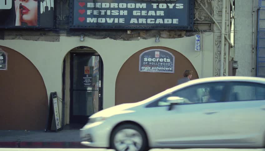 A man slams the pay phone against the booth