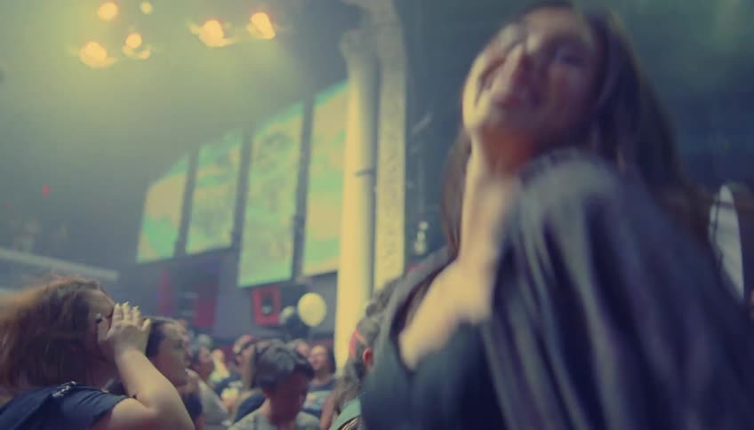 People smile as they dance on the dance floor of a club