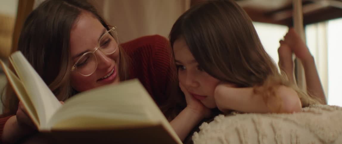 A woman is reading a book with her daughter