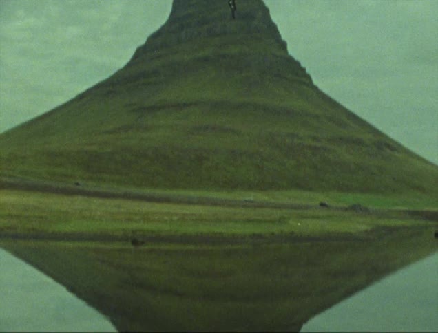 Icelands kirkjufell reflected on the surface of the water on a cloudy day