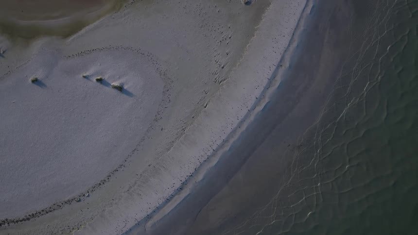 Waves move against the side of a small island