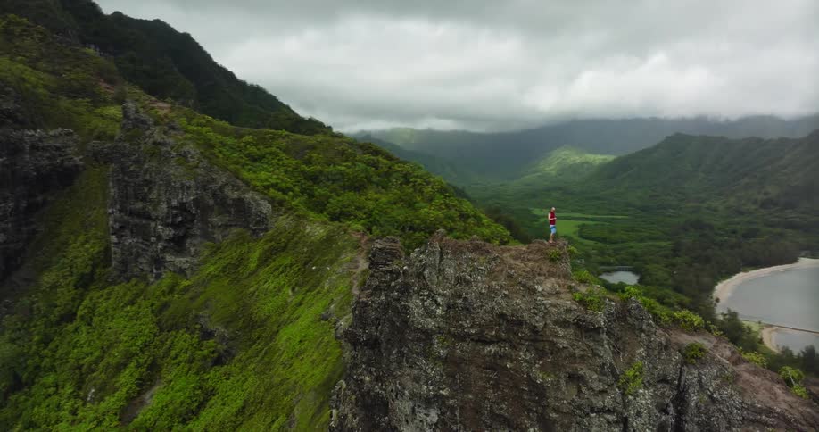 A man is standing on the peak of the mountain