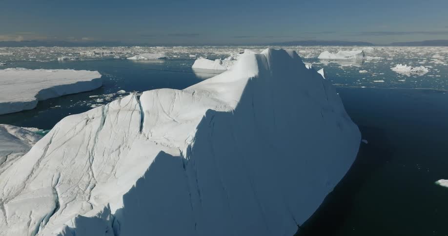 Icebergs and large chunks of ice floating on the ocean on a bright day