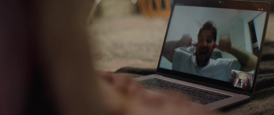 Father makes faces on a video call to amuse his daughter