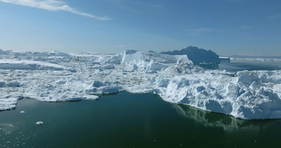 Aerial view of a glacier meeting with the ocean under a deep blue sky