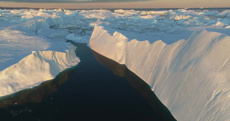 Aerial view of a glacier meeting with the ocean at evening