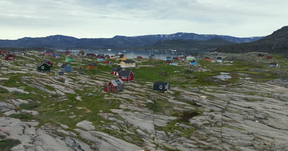 A neighborhood made up of colorful homes sits below a mountain range