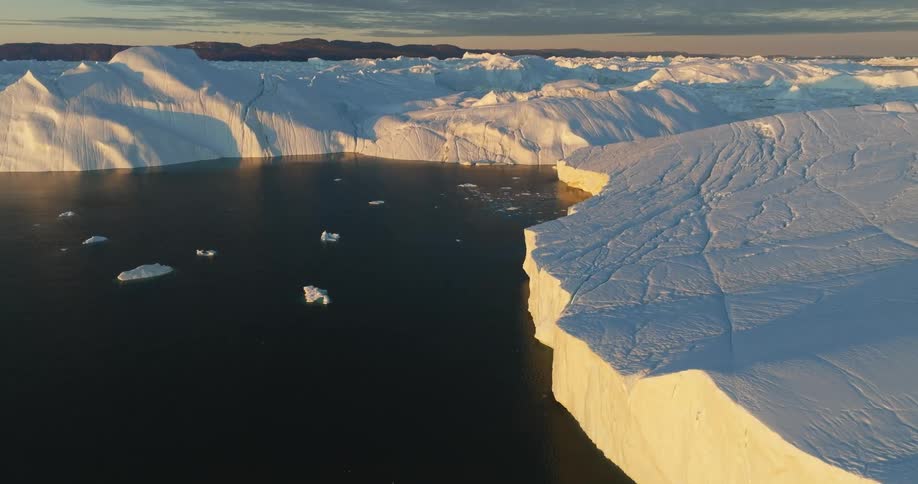 Ice chunks floating in the smooth sea near icebergs and glaciers
