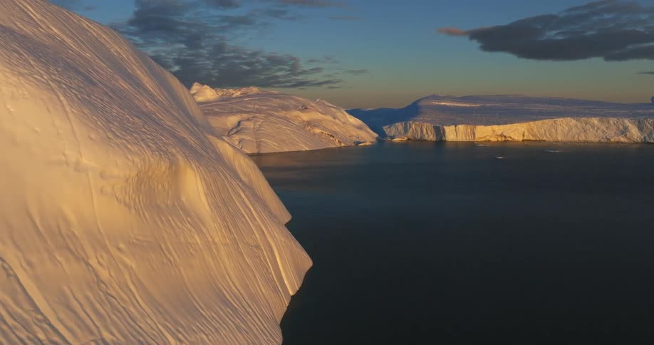 Large icebergs and mounds of snow float in the ocean
