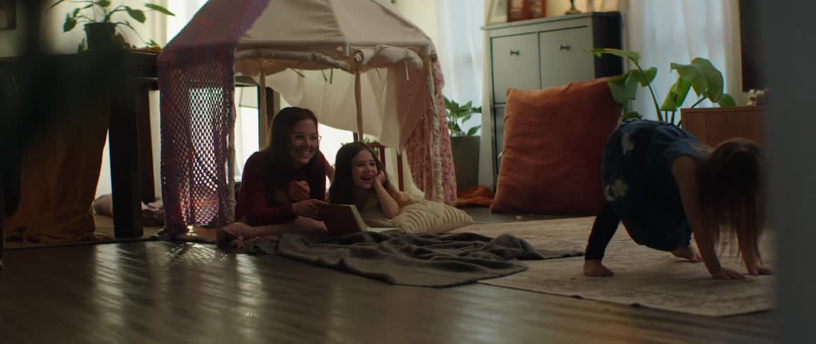 A mother and daughters camp out in the living room