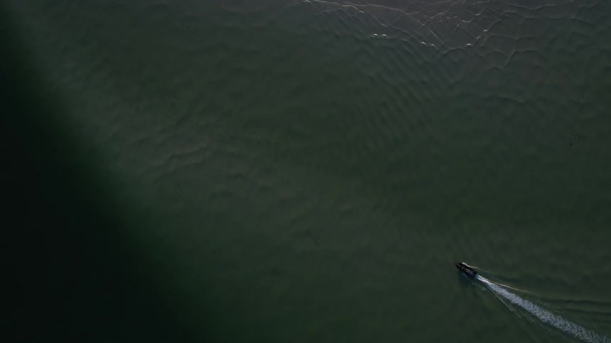 A boat is traveling in the water below