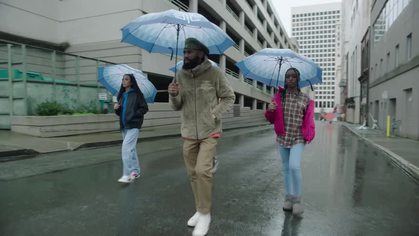 A group of people walk together down a city street under their umbrellas on a rainy day