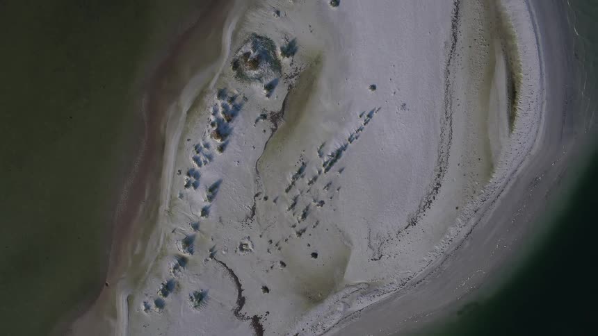 A small island is surrounded by water below