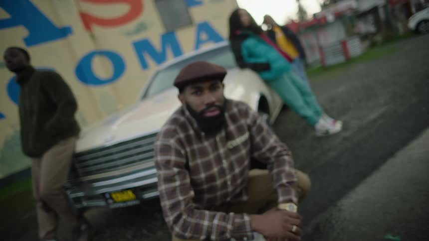 A group of people are standing around a car