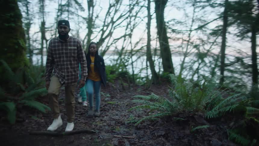 A group of teenagers walk through a forest