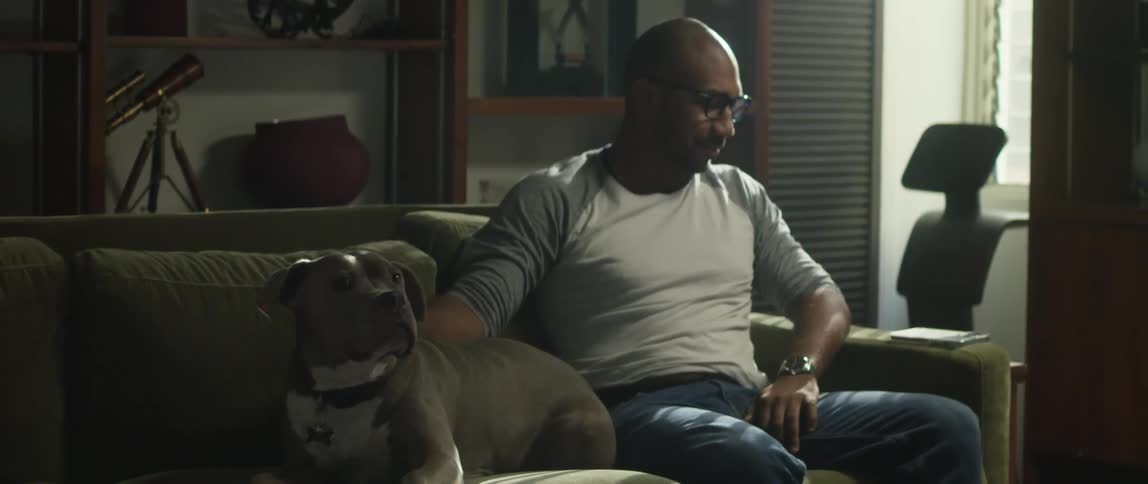 A man sitting in a room petting his dog