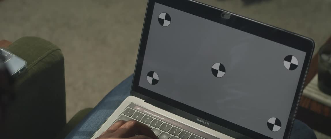A person is sitting on a couch with their laptop