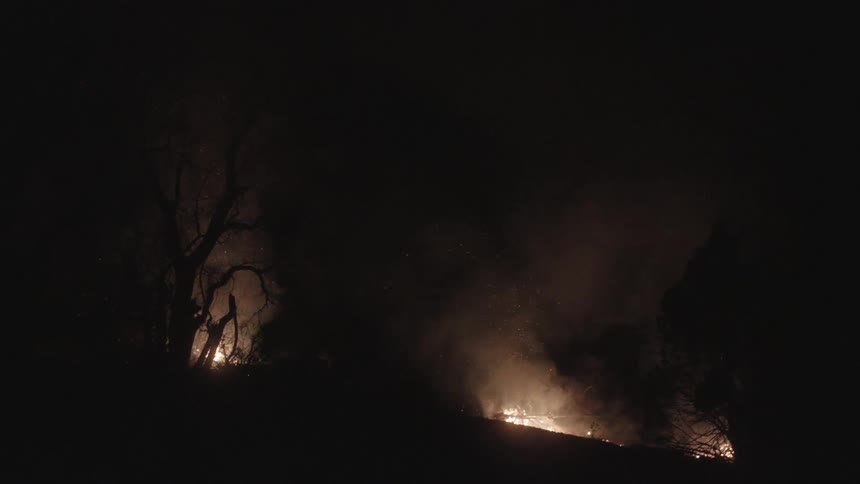 Fires burn on a hill at night