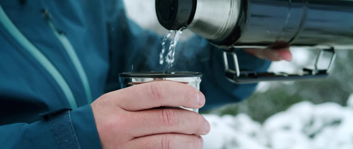A man pours water from a thermos