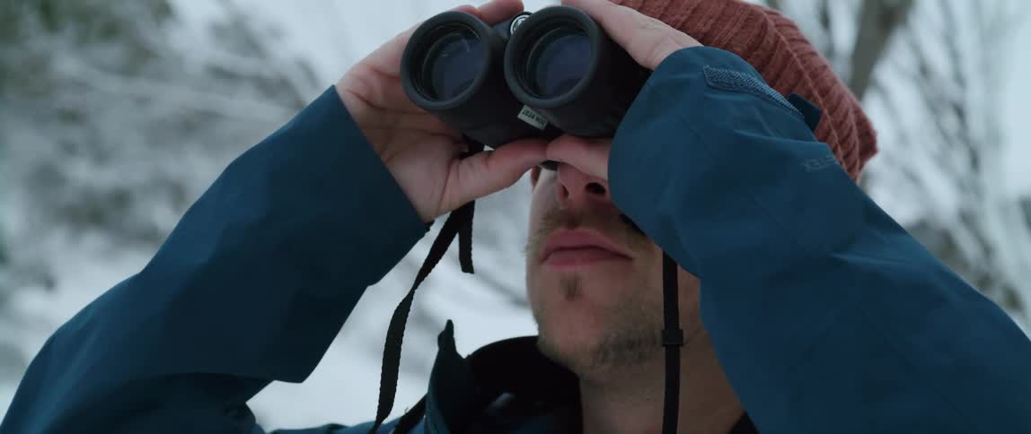A man looking through binoculars