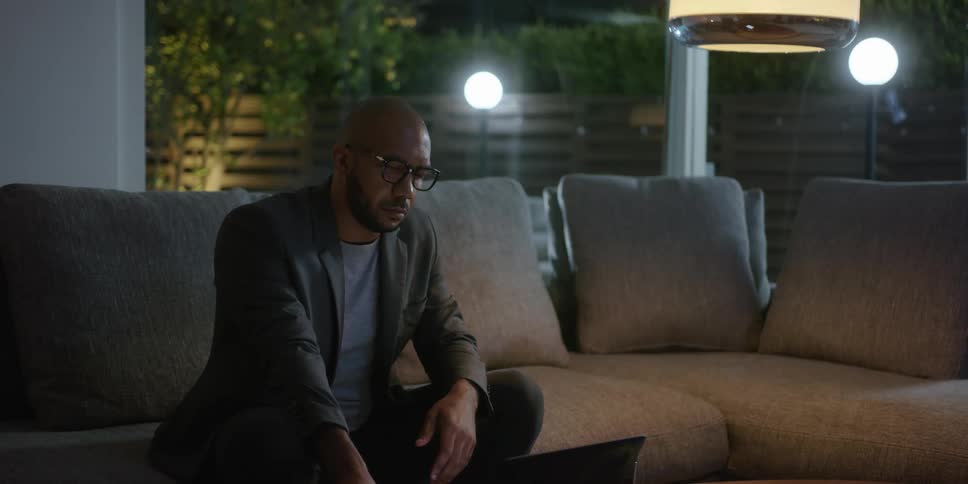 A man sitting on a couch looking at his phone