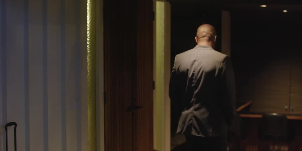 A man looks around as he walks as if he is leaving forever