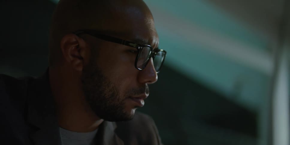 The light is reflecting on the mans glasses