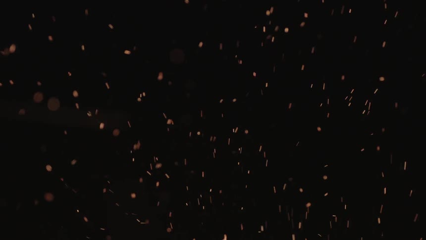 Embers fly through the dark, night sky