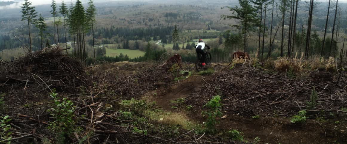A person riding a motocross bike speeds down the slopes of a mountain