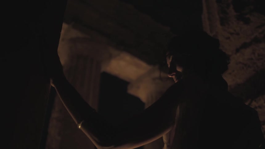 A woman is tracing her hand against a wall at night